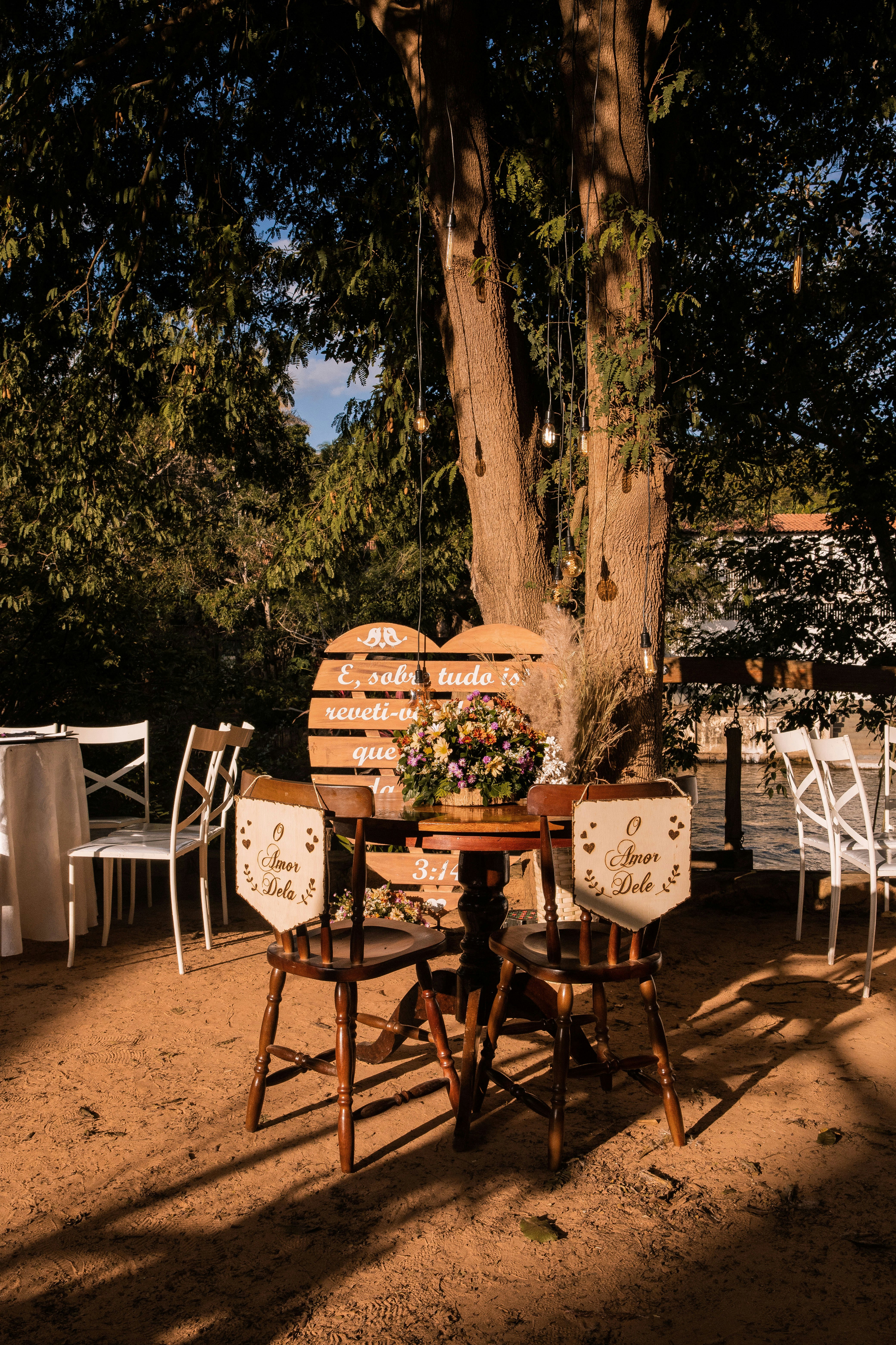 brown wooden table and chairs near trees during daytime